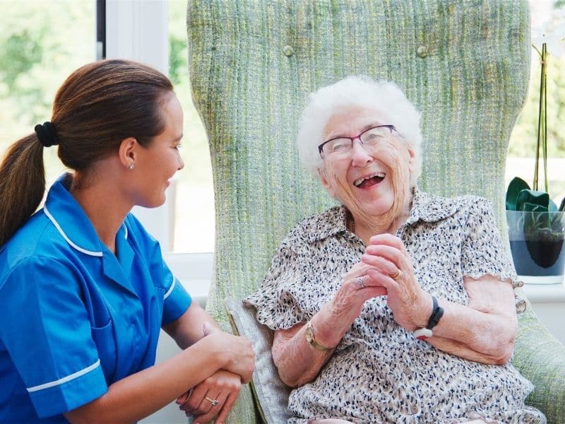 caregiver supporting elderly woman during long-term senior care planning in a comfortable care setting