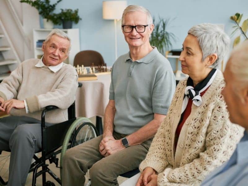 senior housing advocate supporting older adults in group setting within a senior living community