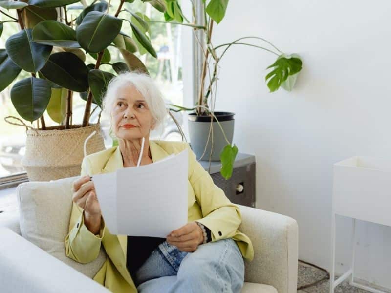 older adult reviewing documents at home with support from senior housing help for families