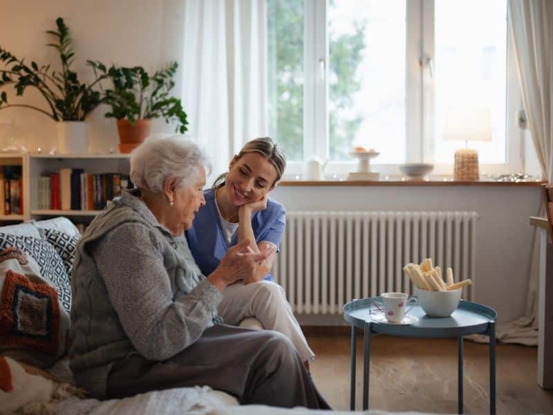 senior housing advisory services discussion between caregiver and older adult in comfortable home setting