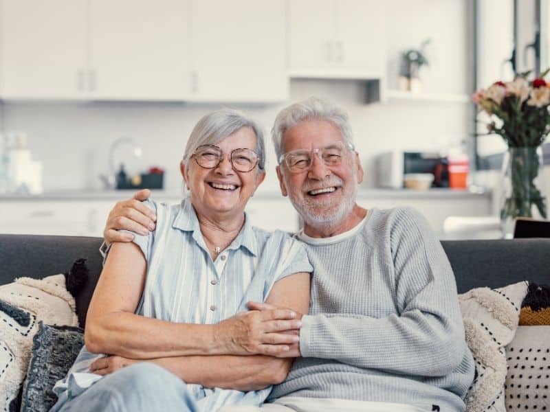 senior couple smiling at home after receiving support from senior care placement services
